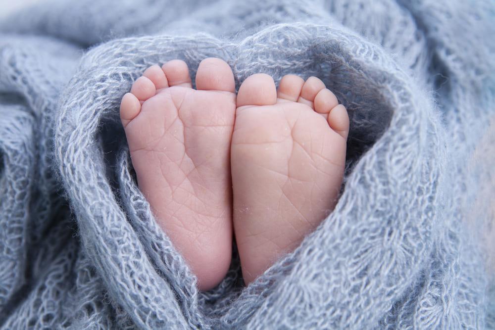 Pieds de bébé enveloppés dans une couverture de laine  bleue