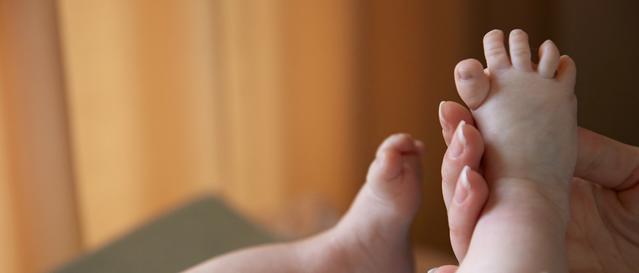 Un nouveau-né se faisant masser le pied